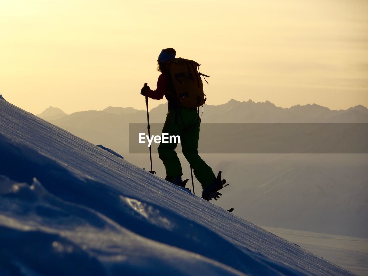 FULL LENGTH OF MAN ON SNOWCAPPED MOUNTAIN AGAINST SKY DURING WINTER