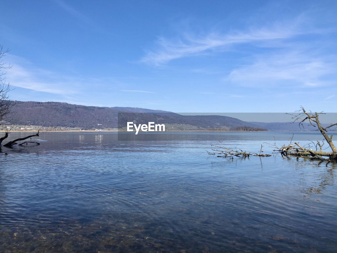 SCENIC VIEW OF LAKE BY MOUNTAINS AGAINST BLUE SKY