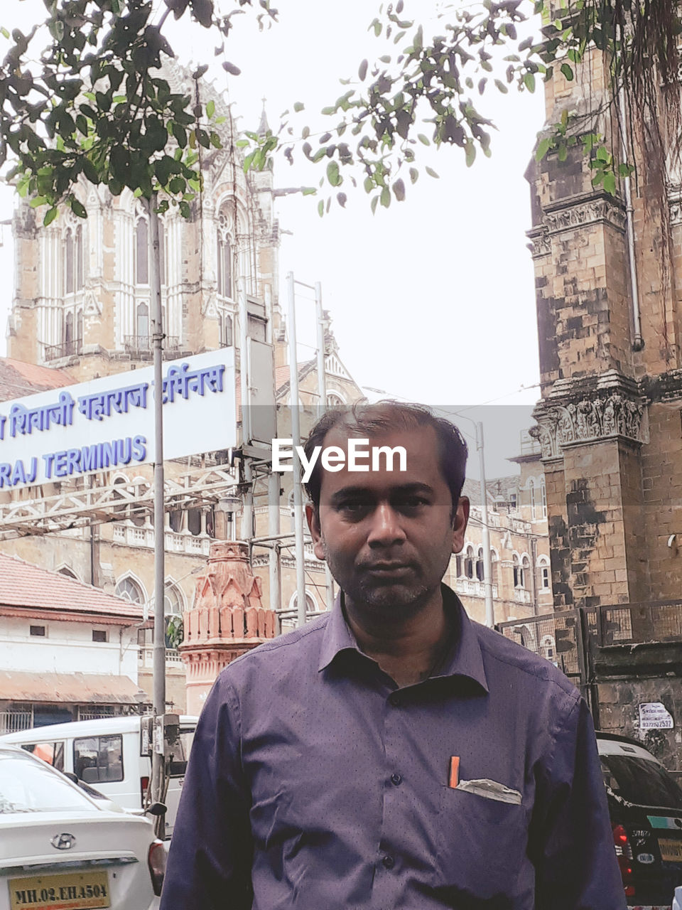 PORTRAIT OF YOUNG MAN STANDING ON CITY