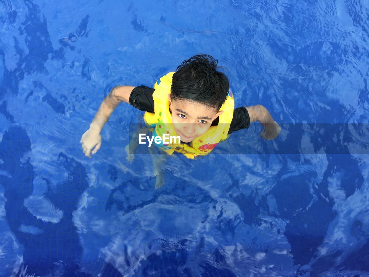 High angle portrait of boy swimming in pool