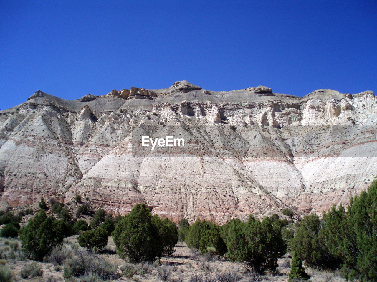 Low angle view of rock formation against clear blue sky