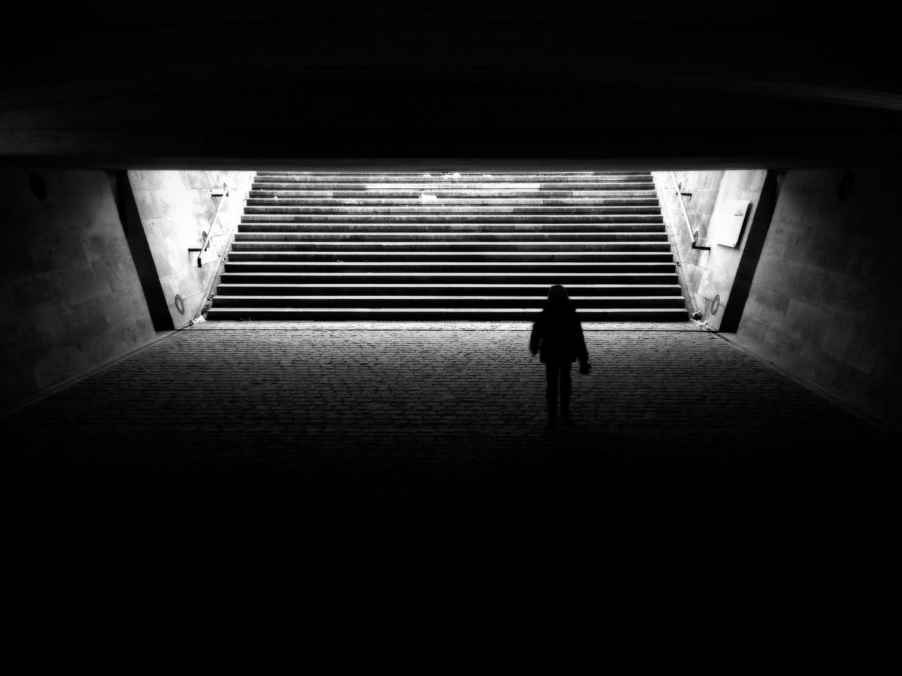 Silhouette person walking in tunnel