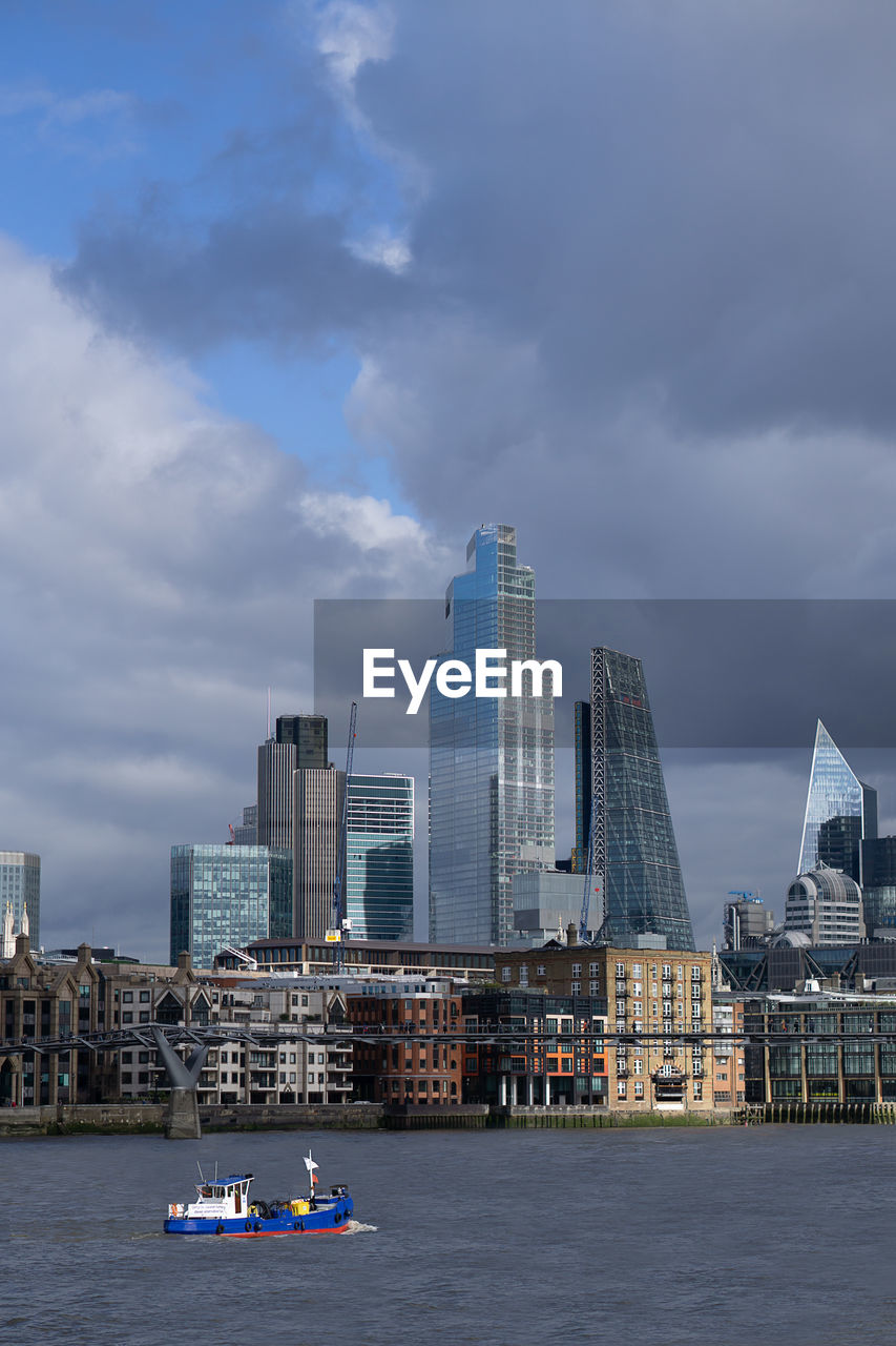 VIEW OF BUILDINGS BY RIVER AGAINST SKY