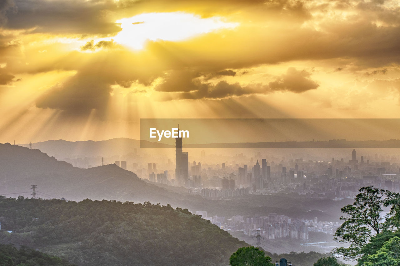 AERIAL VIEW OF CITY AGAINST CLOUDY SKY