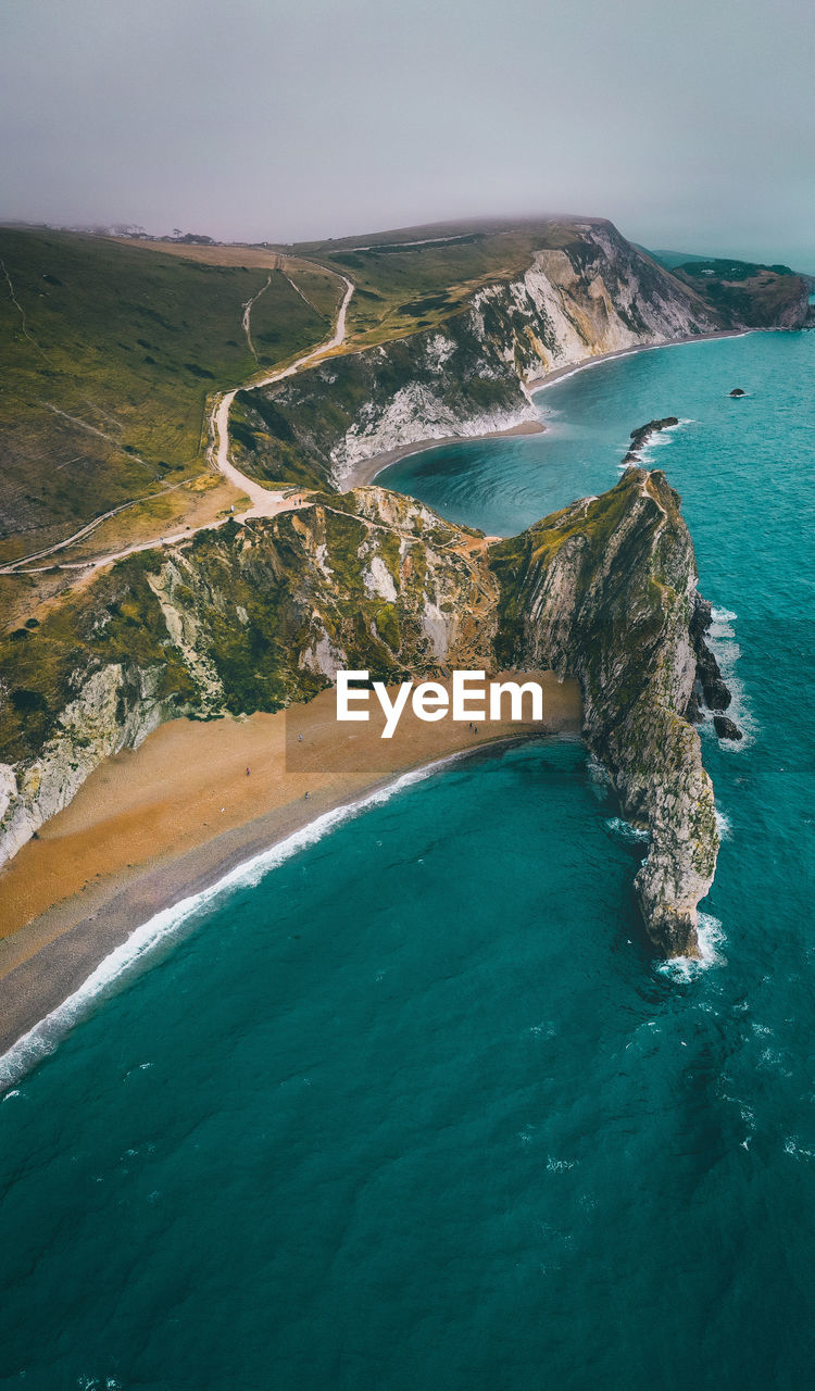 HIGH ANGLE VIEW OF SEA SHORE AGAINST SKY