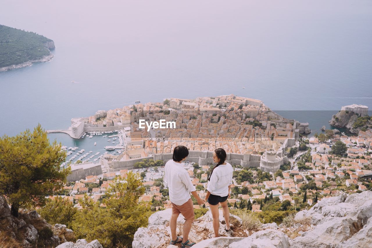 Rear view of couple enjoying the view of a croatian village on the sea