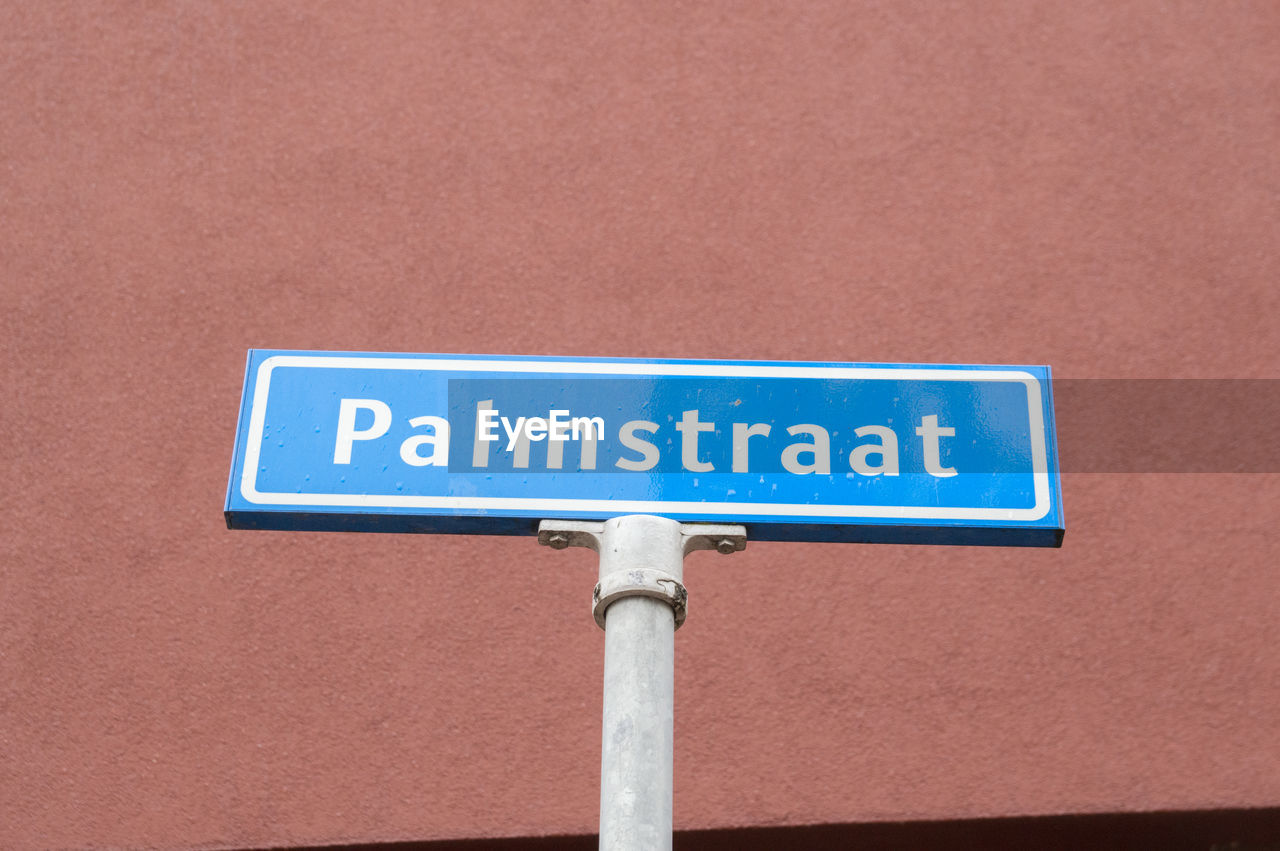 LOW ANGLE VIEW OF ROAD SIGNS ON WALL