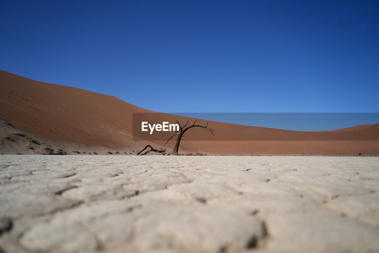 scenic view of desert against blue sky