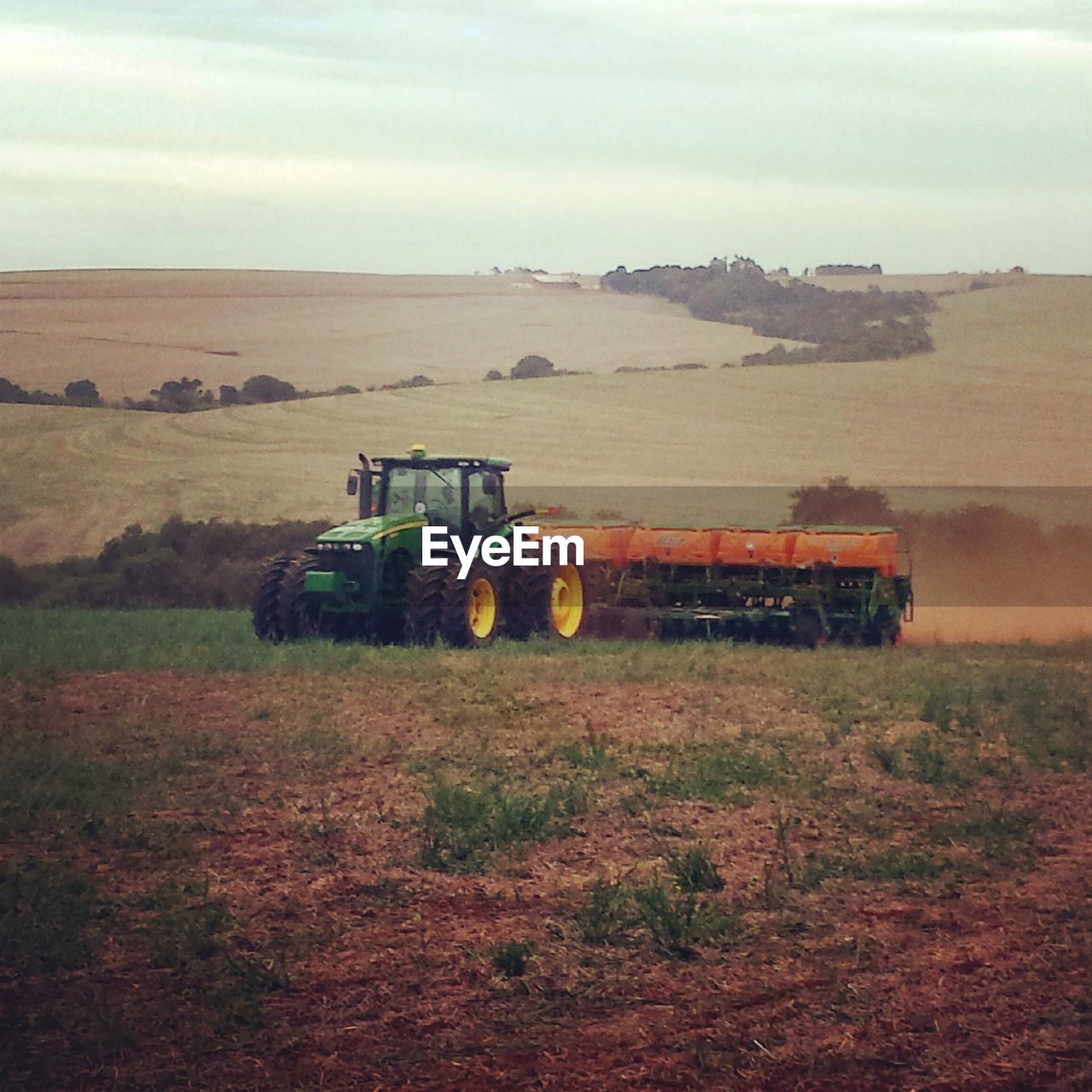 TRACTOR ON FIELD AGAINST SKY