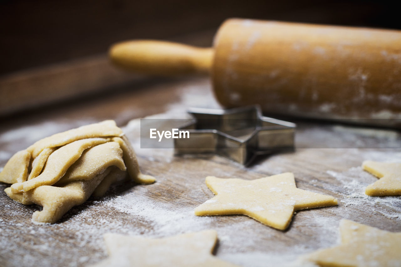 Close-up of star shape cookies and rolling pin with cutter on table