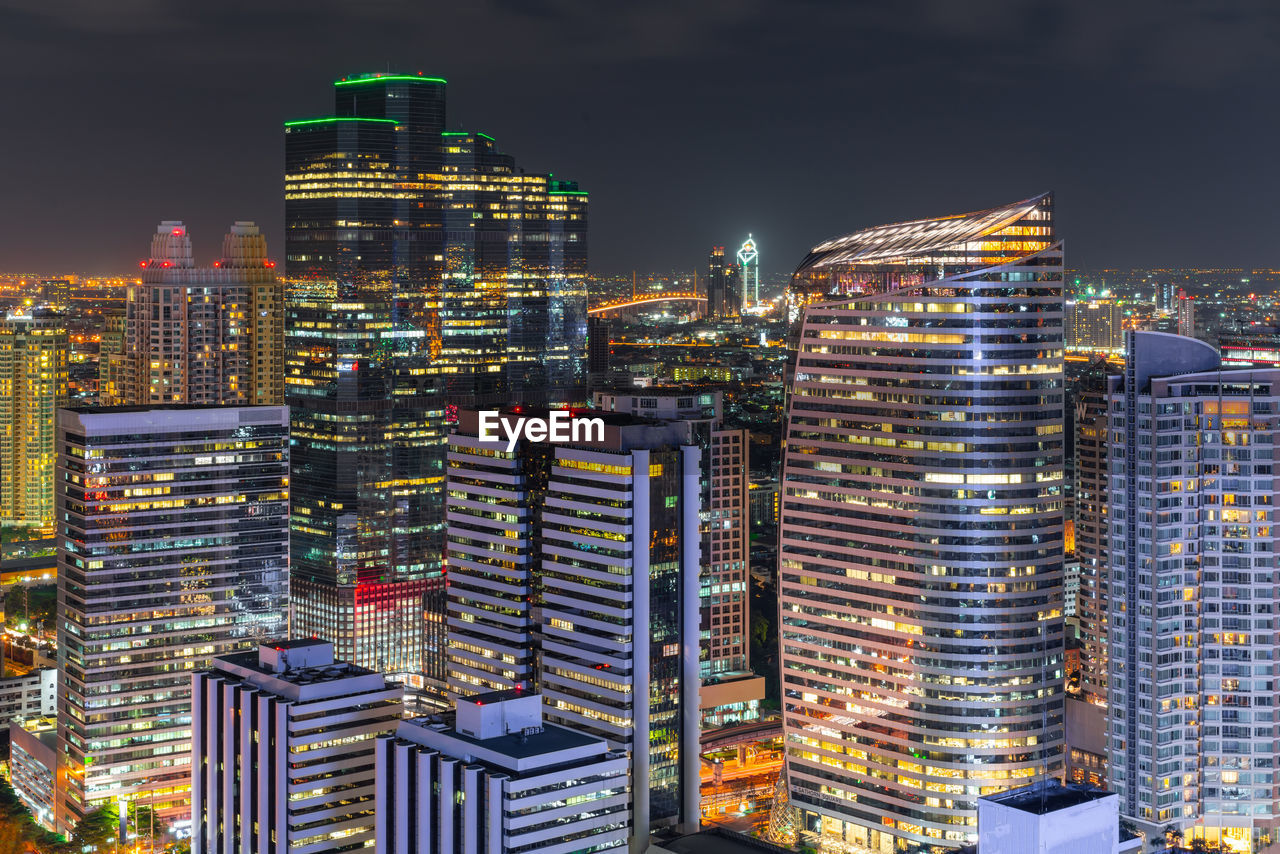 Illuminated buildings in city against sky at night