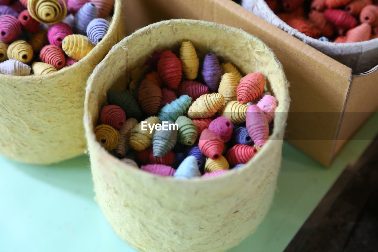 High angle view of multi color paper roll in container on table