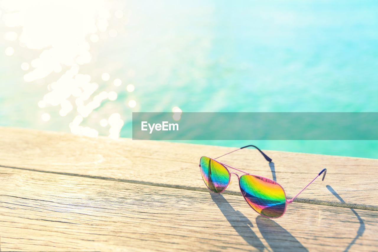 High angle view of multi colored sunglasses on swimming pool decking 