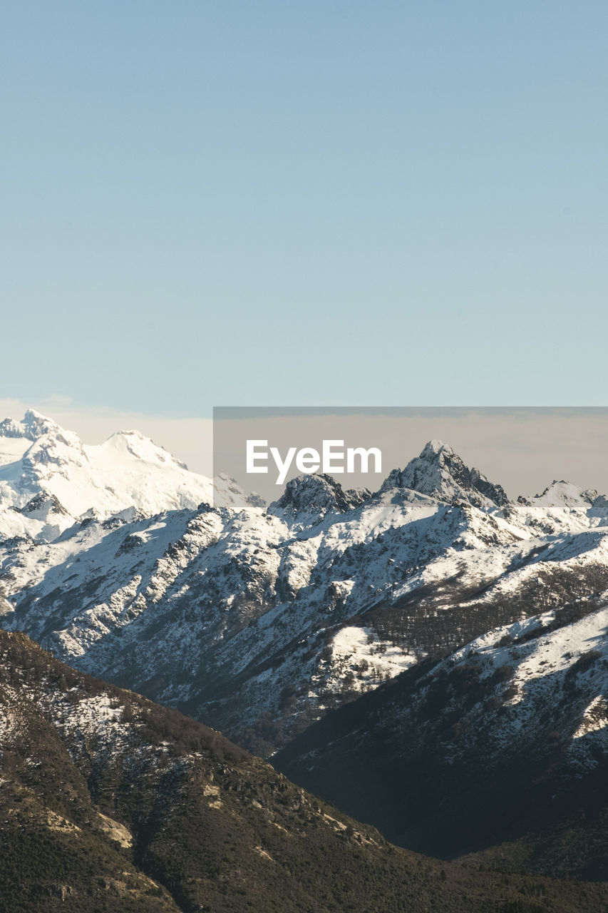 Scenic view of snowcapped mountains against clear sky 
