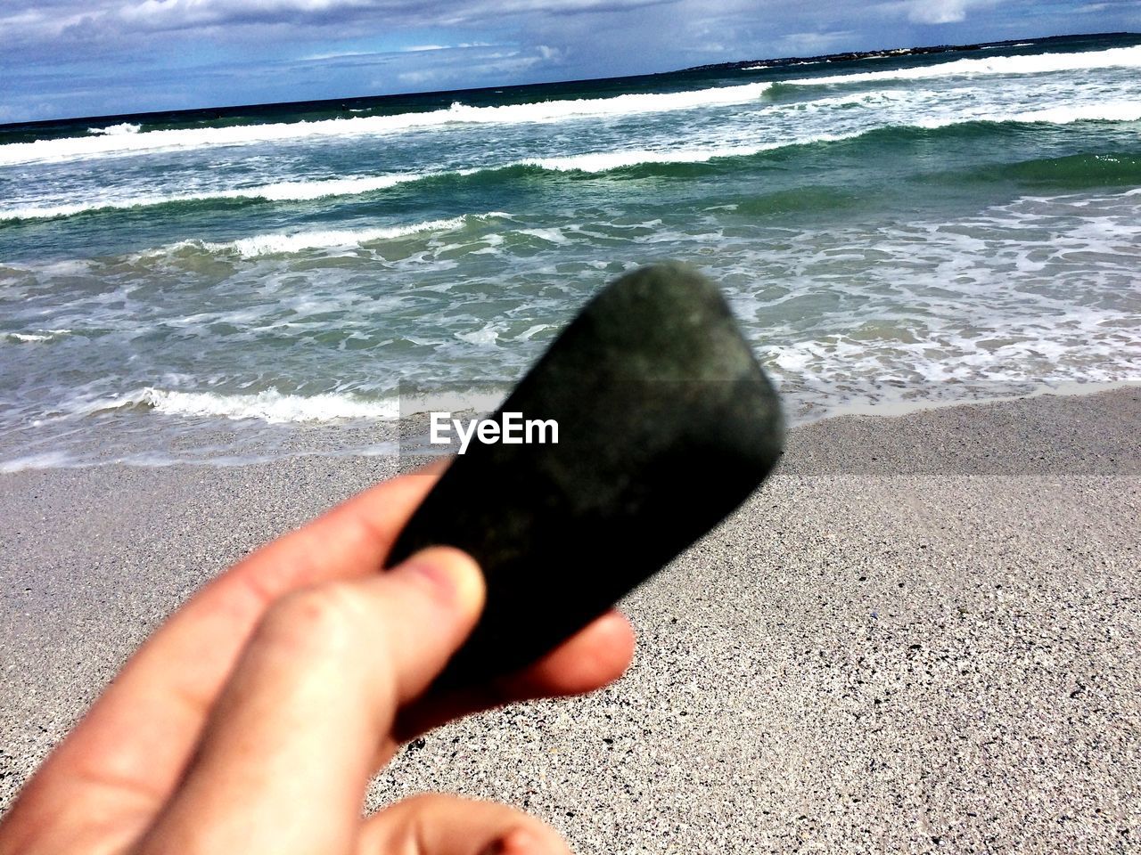 CLOSE-UP OF HAND HOLDING SAND ON BEACH