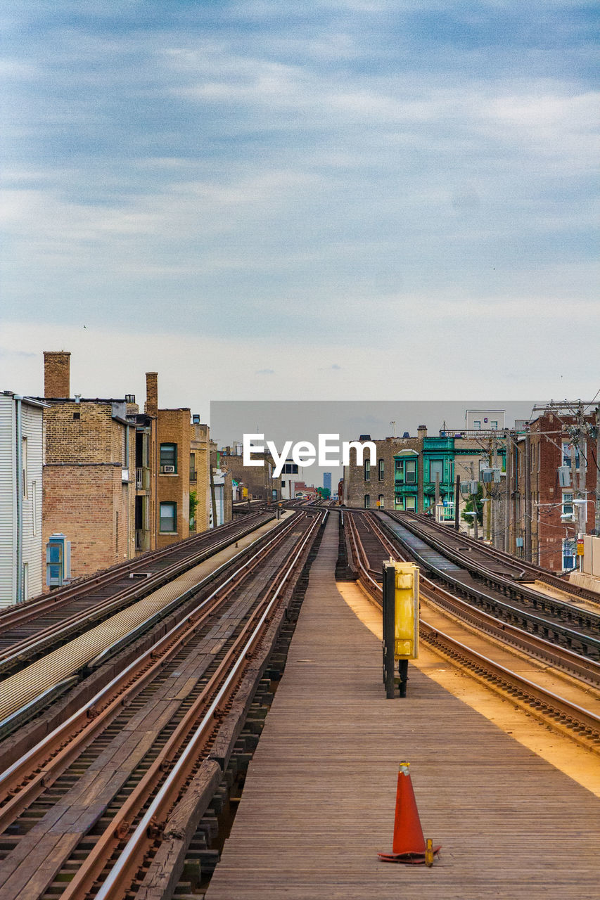 RAILROAD STATION PLATFORM AGAINST SKY IN CITY