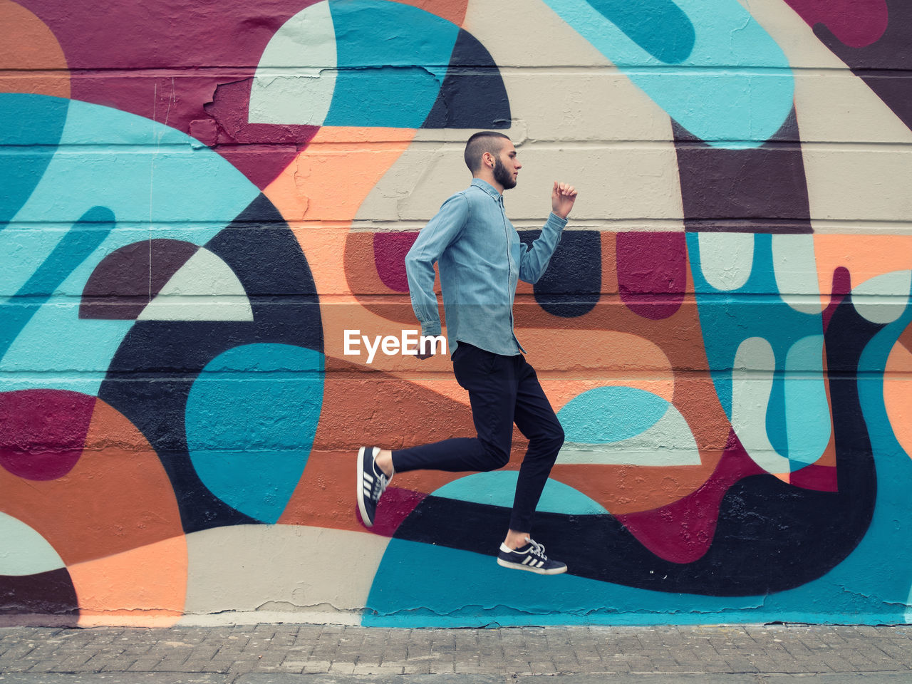 FULL LENGTH OF YOUNG WOMAN WALKING ON WALL