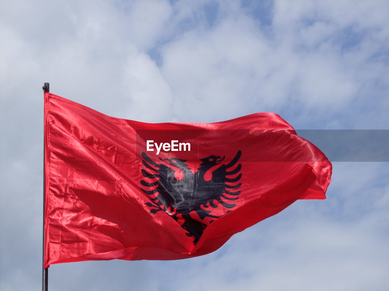 Low angle view of albanian flag against sky