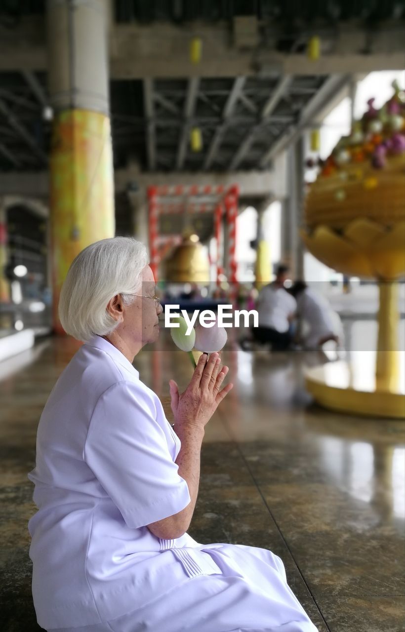 Woman holding flower buds in temple