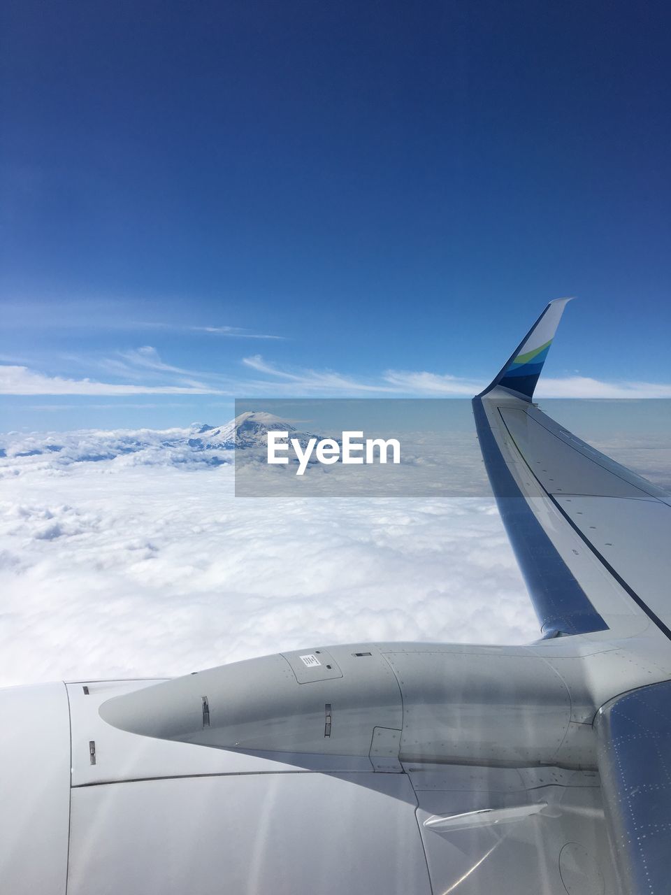 AIRPLANE WING FLYING OVER CLOUDS