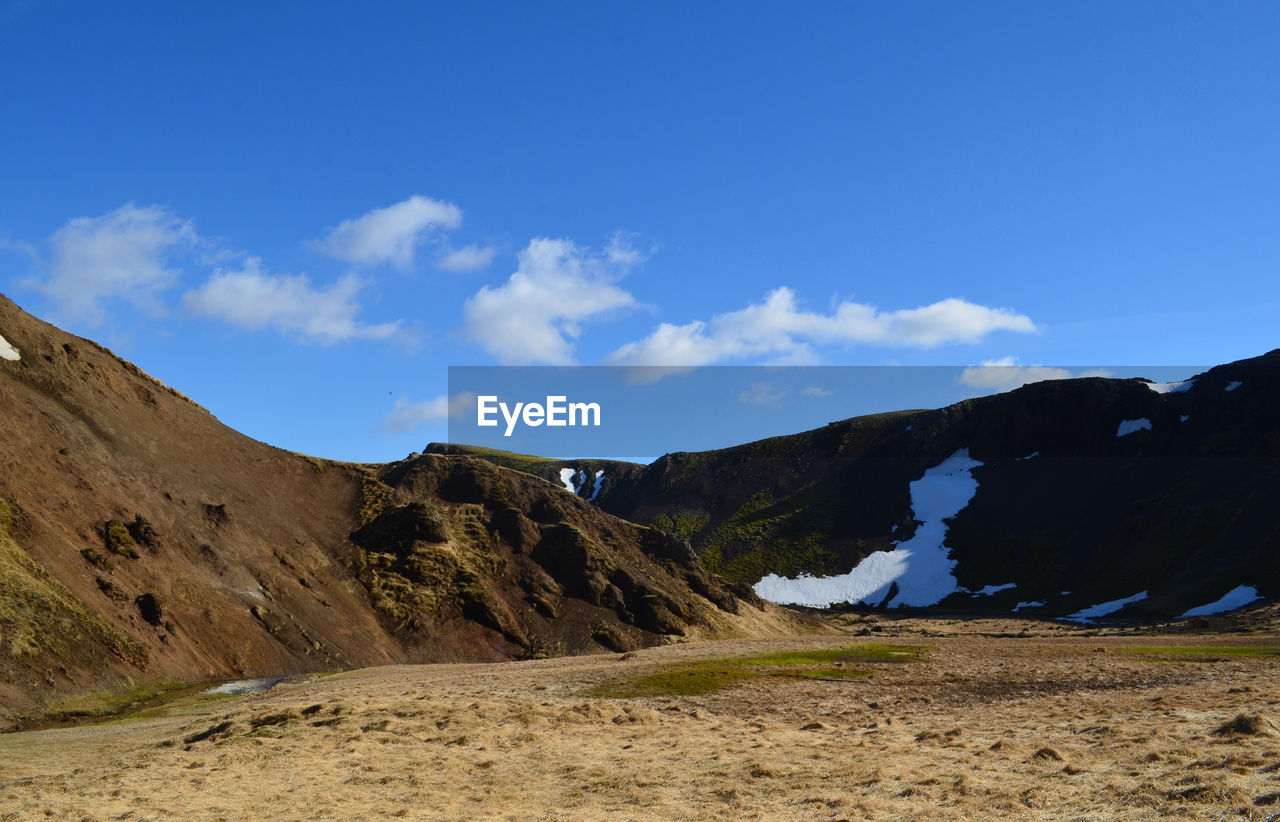 Spring thaw around a valley with snow melting on surrounding mountains.