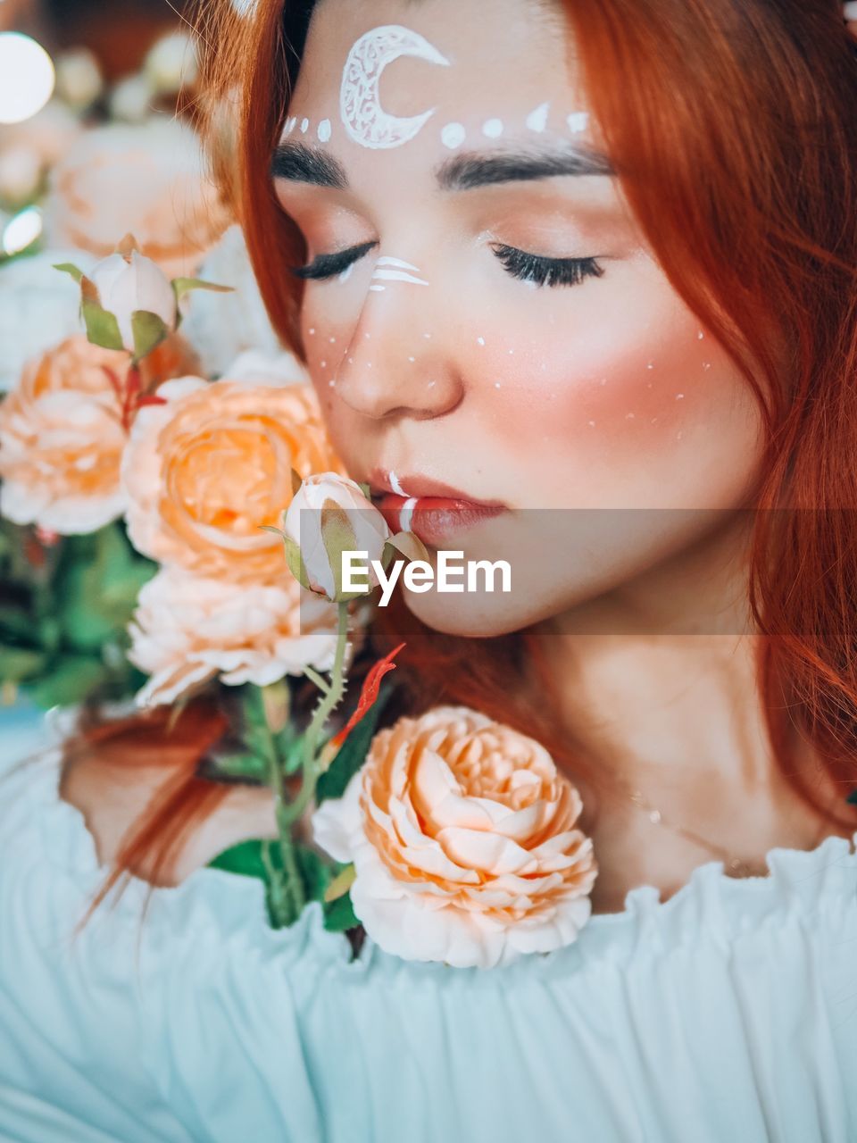 CLOSE-UP PORTRAIT OF A BEAUTIFUL WOMAN WITH RED FLOWER PETALS