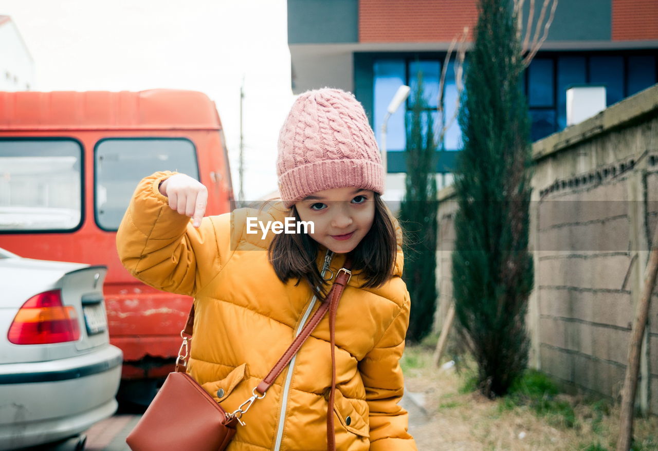 portrait of young woman wearing hat standing on street