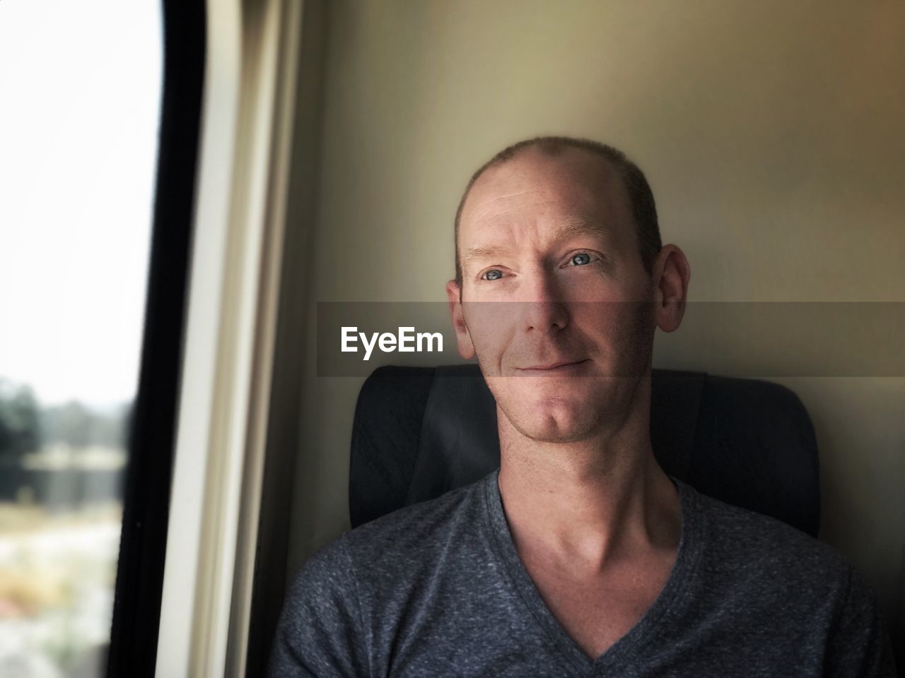 Portrait of man sitting by window