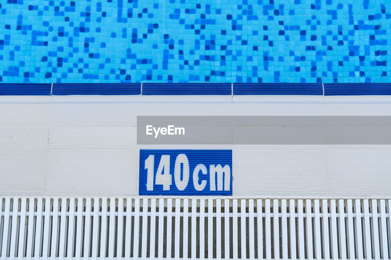 CLOSE-UP OF TEXT ON SWIMMING POOL AGAINST WALL