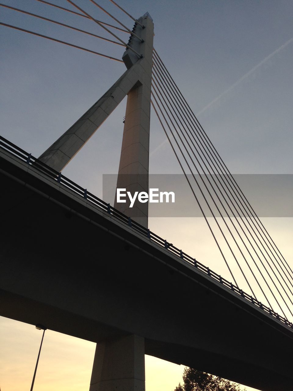 Low angle view of modern bridge against sky at dusk