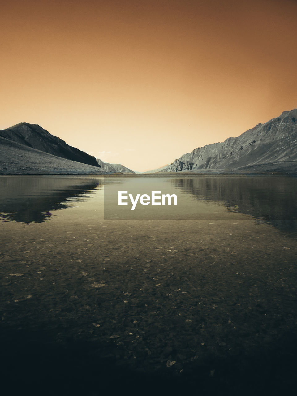 Scenic view of lake against clear sky during sunset