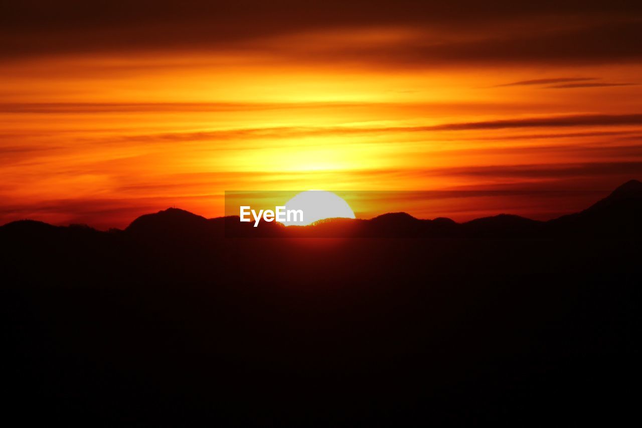 Idyllic shot of mountains against orange sunset sky