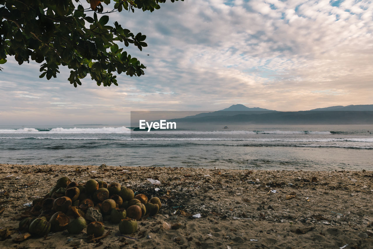 Scenic view of sea against cloudy sky during sunrise