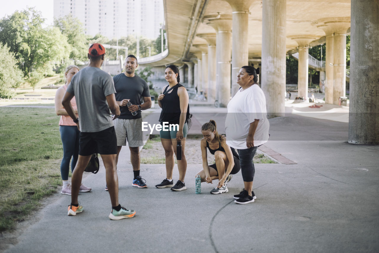 Male fitness instructor assisting team during training session