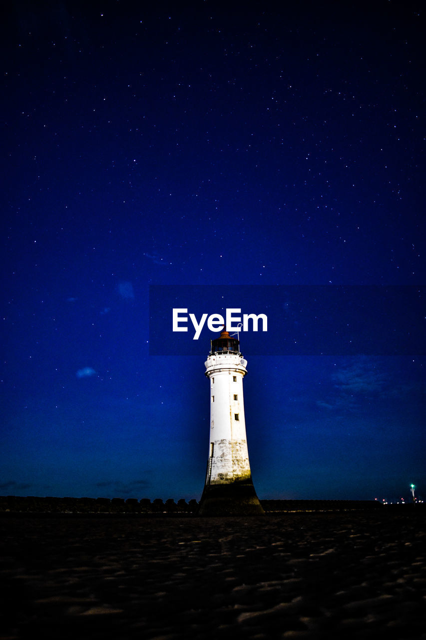 Low angle view of lighthouse against sky at night