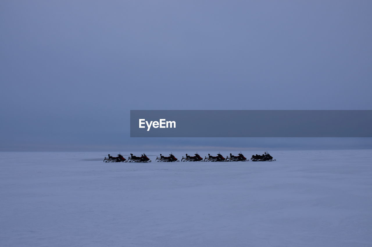 Scenic view of snowbike on sea against clear sky