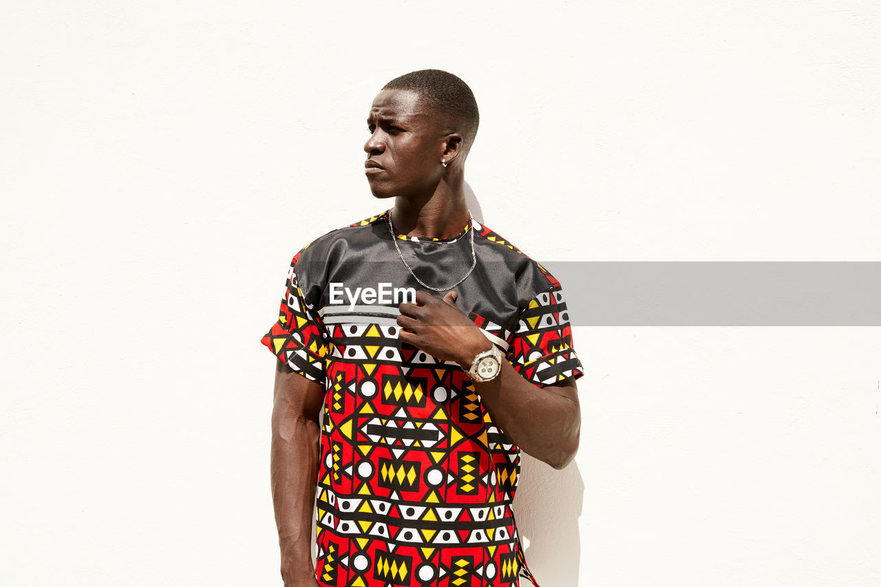 African american male in casual clothes looking away with serious face on white background in city