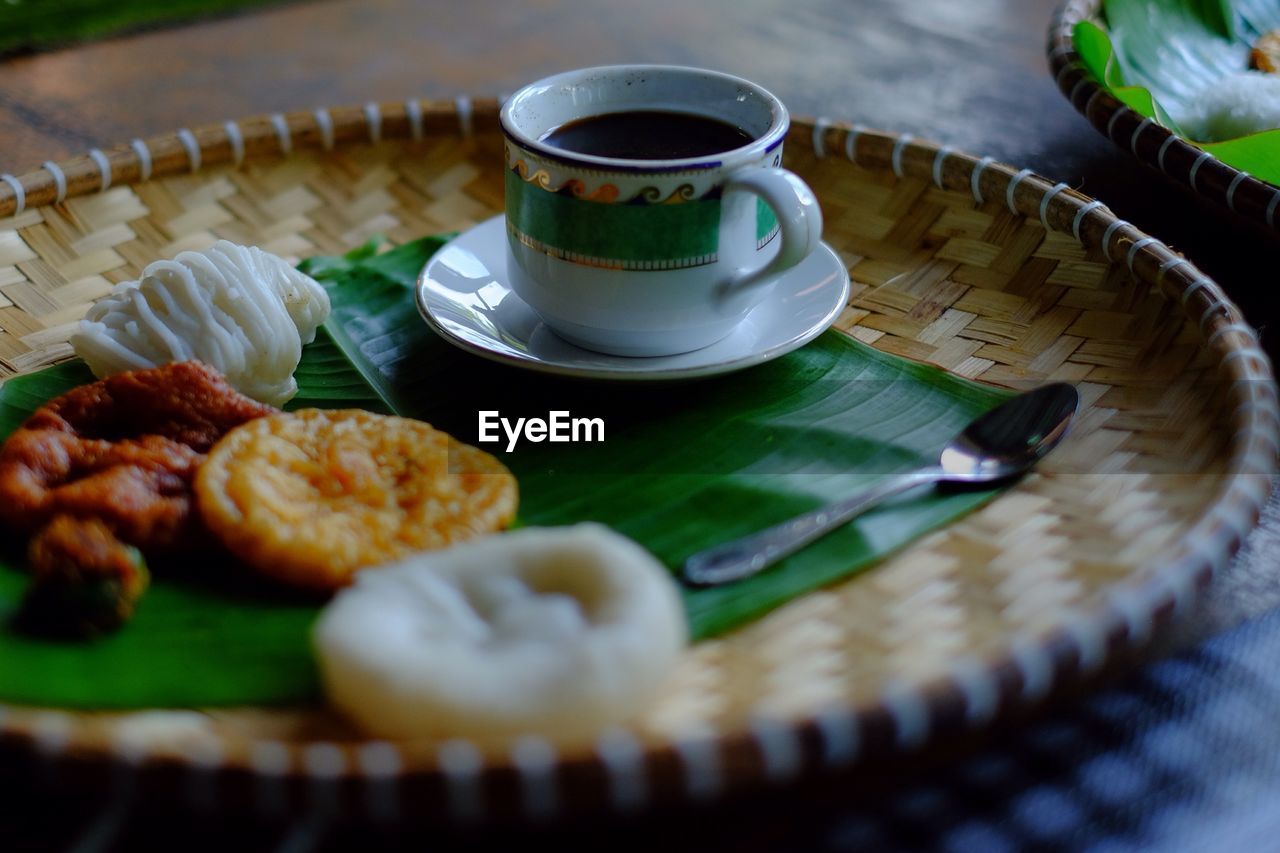 CLOSE-UP OF DRINK IN PLATE WITH TABLE