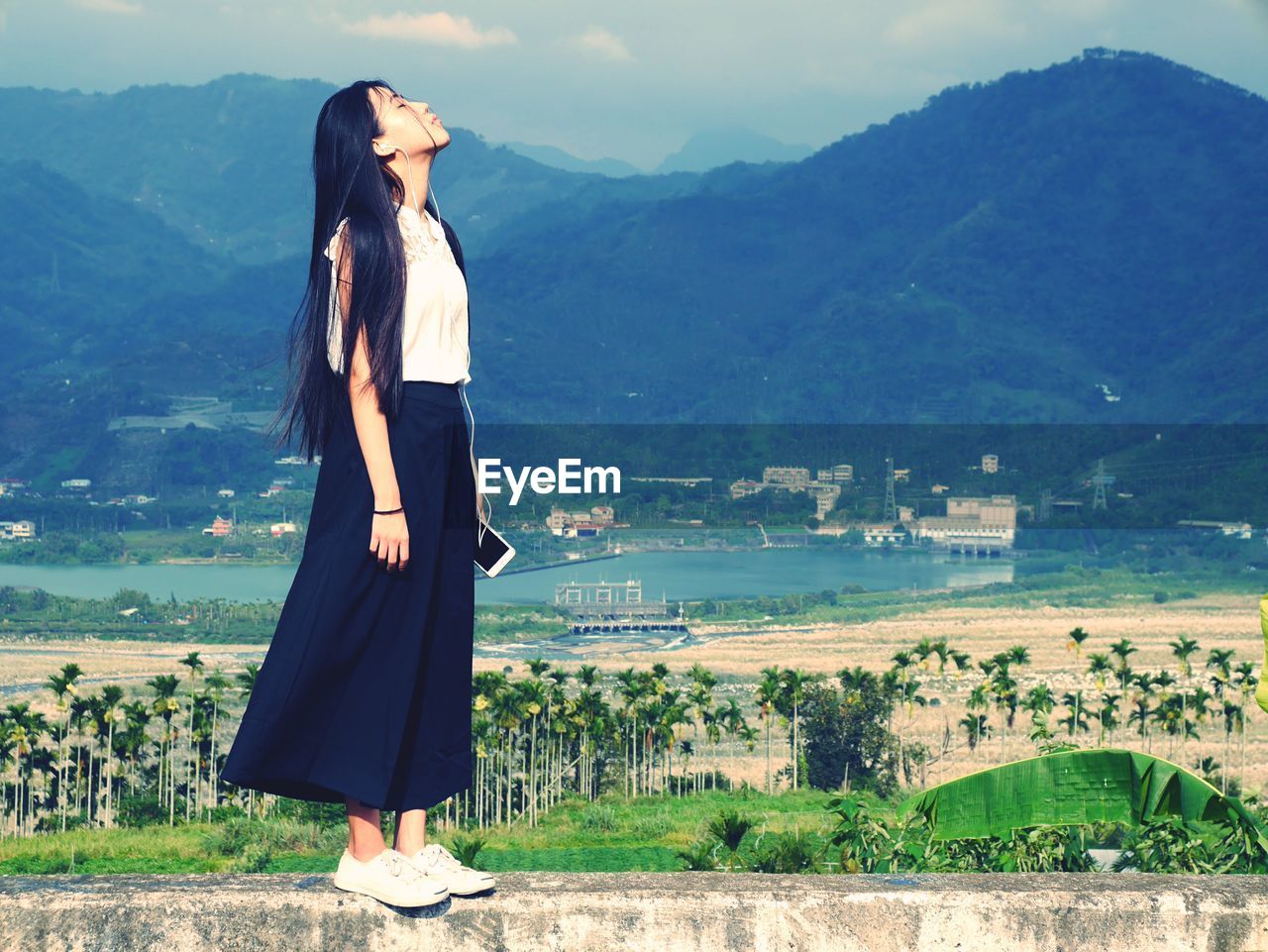 Woman standing on field against mountain range