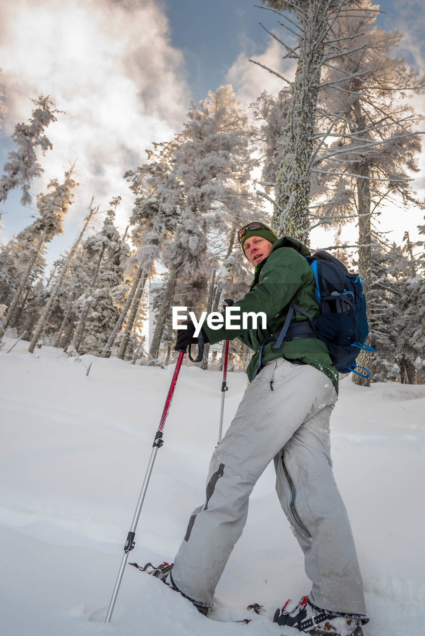 Low angle view of man skiing on snow covered land