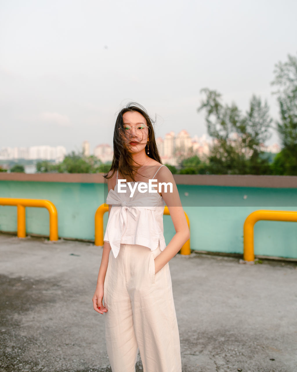 PORTRAIT OF WOMAN STANDING AGAINST SKY