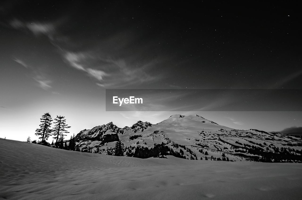 Scenic view of snow covered cascade range against sky at night