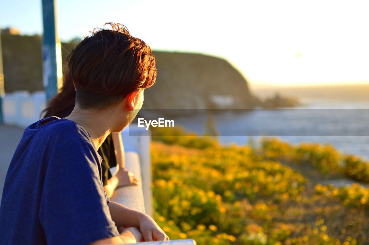 Side view of young man looking at sea