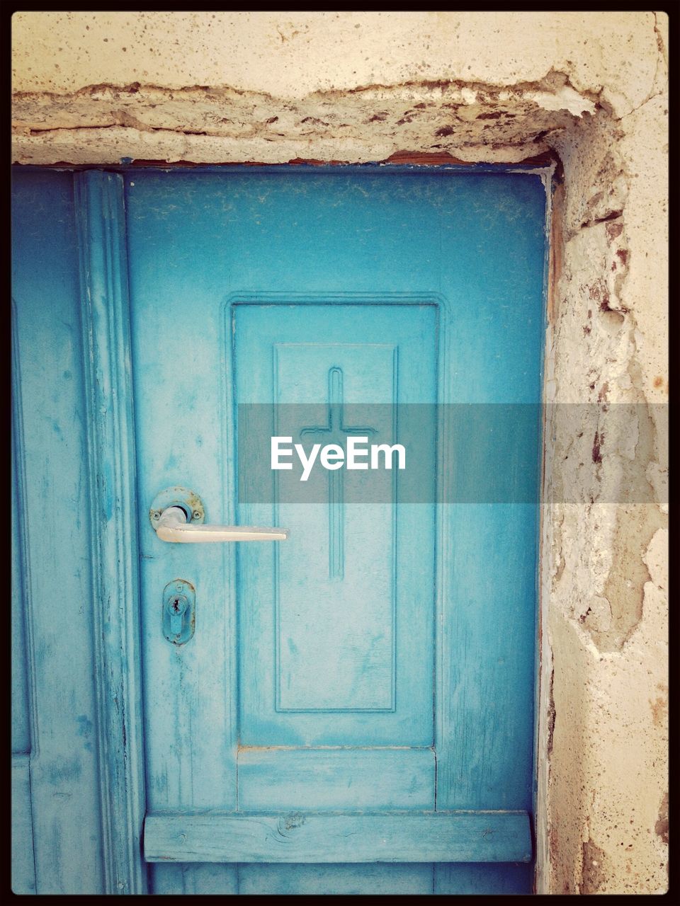 Cross on old blue door