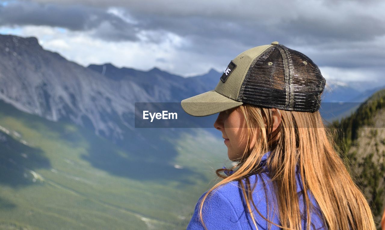 PORTRAIT OF WOMAN AGAINST MOUNTAINS