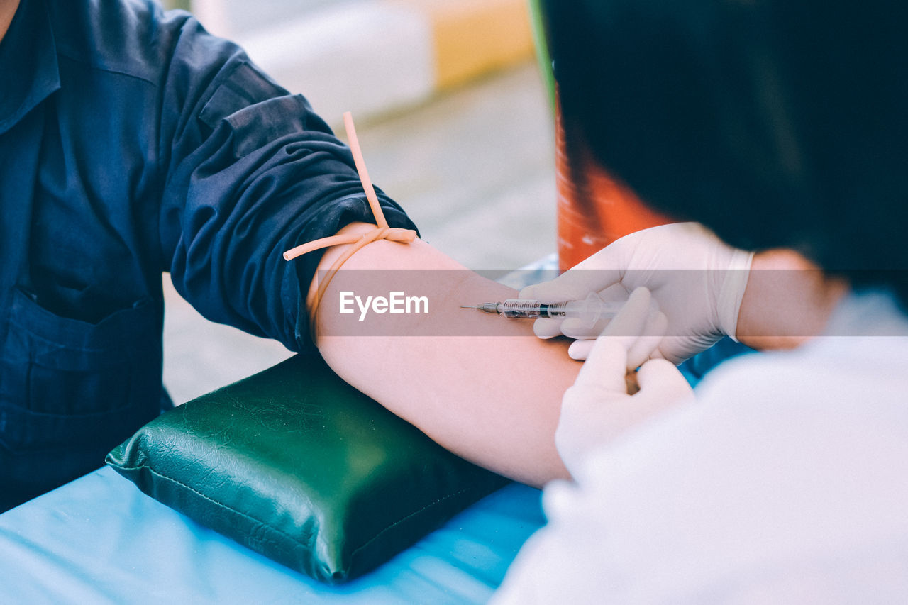 Cropped hands of doctor injecting patient