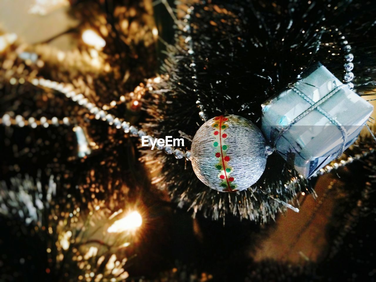 Close-up of bauble hanging on illuminated christmas tree