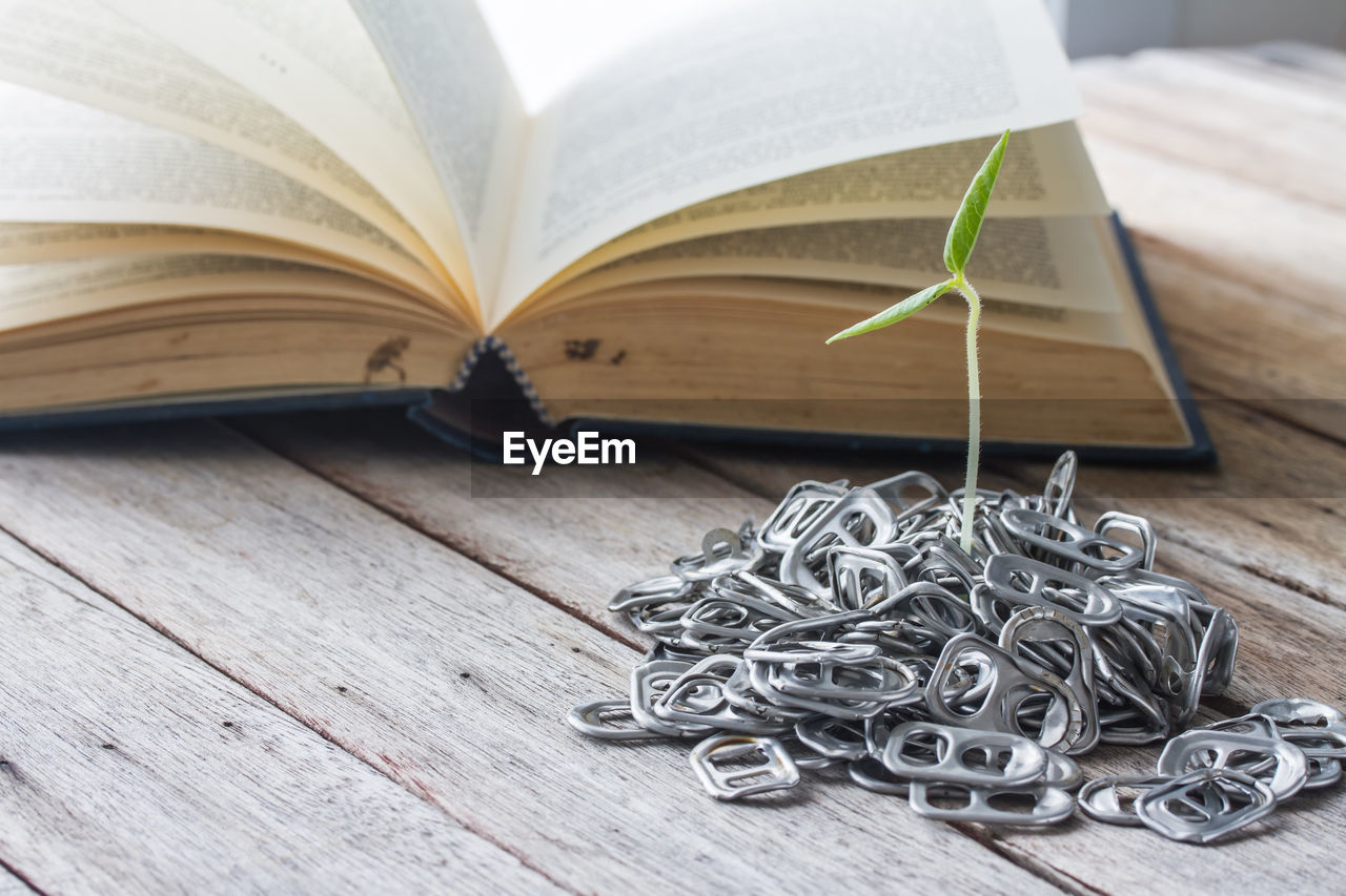 HIGH ANGLE VIEW OF BOOKS ON TABLE AGAINST WALL