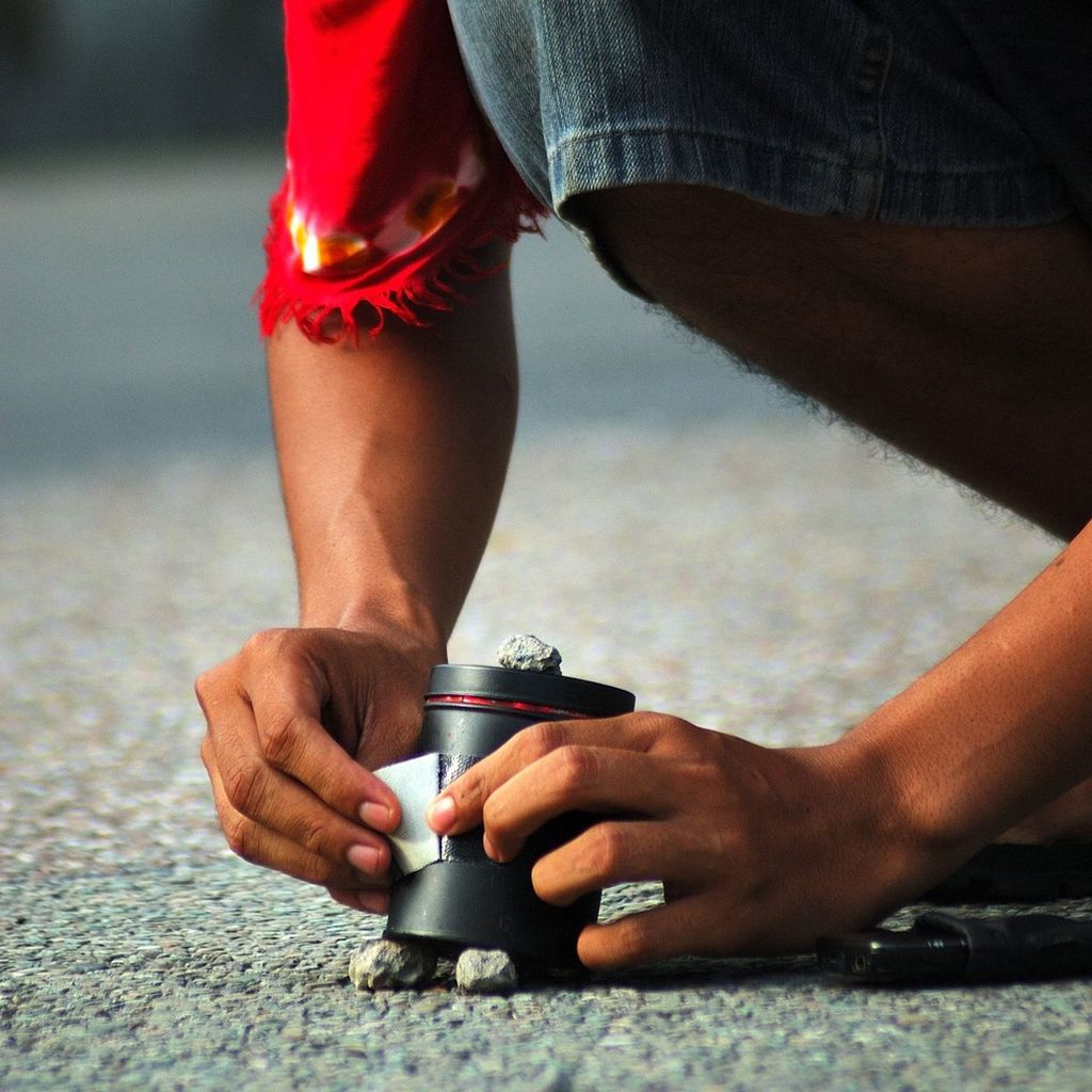 Man applying sticky tape to metal can