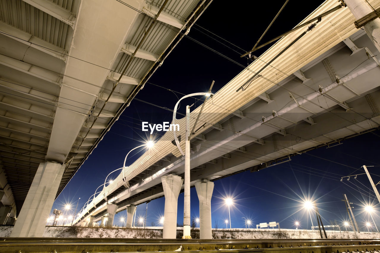 Highway expressway with concrete pillars at night, bottom view. overpass of western speed diameter